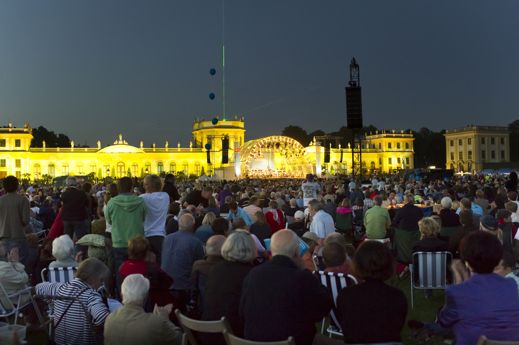 Besucher sitzen auf der Karlswiese vor der Orangerie in Kassel